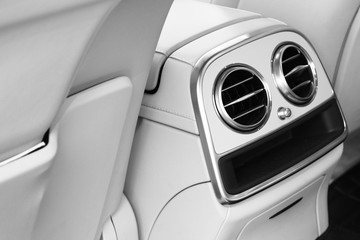 AC Ventilation Deck Luxury Car Interior. Modern car interior details white leather, natural wood. Car detailing. Black and white