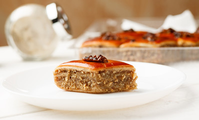 Oriental sweets with walnut in a white plate on a wooden table
