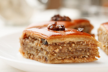Oriental sweets with walnut in a white plate on a wooden table