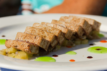 Exquisite plate of red tuna medallions and potatoes decorated with apple jam at fine dine restaurant. Delicious fish dish