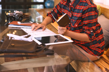 Young hipster woman tourists. View travel map in coffee shop.