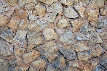 The wall of rough grey and brown sharp stones