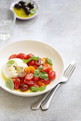 
    Mozzarella and cherry tomatoes salad with fresh basil and olives. 