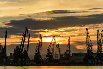 Fototapeta premium Cranes silhouette in the Varna Harbor at sunset.