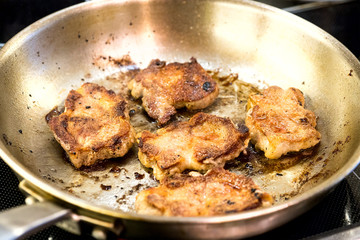 fried meat in a frying pan, cooking