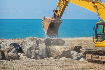 excavator works on the sea coast
