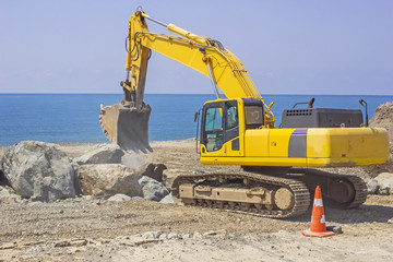 excavator works on the sea coast
