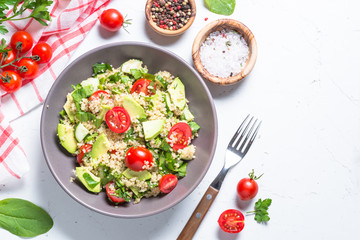 Quinoa salad with spinach, avocado and tomatoes top view.