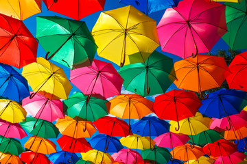 Fototapeta na wymiar Lots of colorful umbrellas in the sky. City decoration