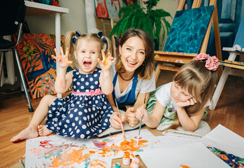 Happy mom and her child  playing with finger paint . Games with children with paint.Early ...