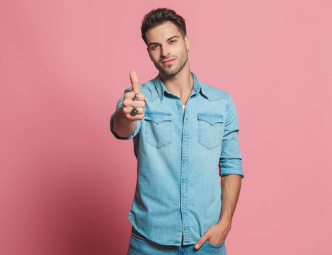 relaxed casual man makes thumbs up sign while standing