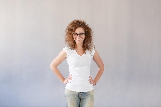 Horizontal shot of happy caucasian woman with positive smile, wear roung glasses and casually, has crisp red hair. Smiling adorable glad woman rejoices success, having good mood. Happy people