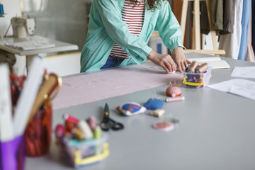 Close up young designer drawing with soap on textile in cozy sewing workshop