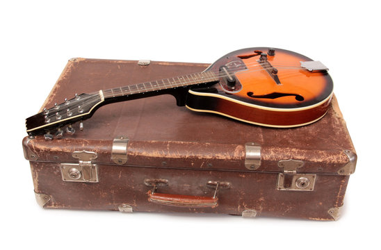Old suitcase and mandolin in country style on a white background