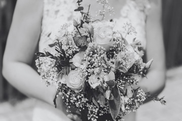 Hochzeit - Braut im weißen Kleid hält Blumenstrauß