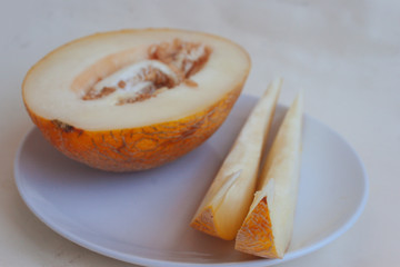 Melon on a plate, half and slices. Candid.