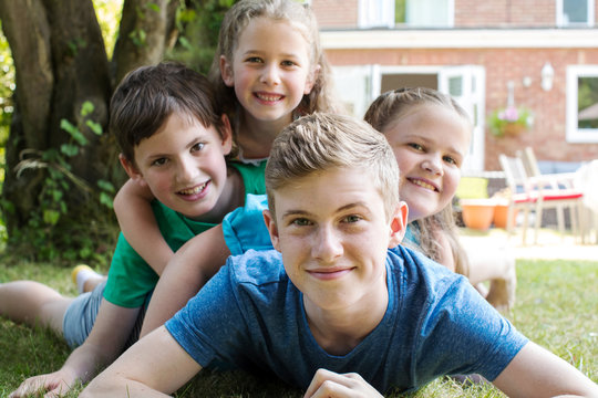 Portrait Of Four Brothers And Sisters Lying In Garden At Home