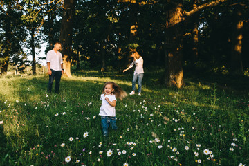Naklejka na ściany i meble beautiful family having fun together in forest on summer day