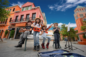 kids playing street musics song on the city walking street for donate, endow, contribute and dole...
