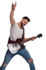 excited young man with guitar makes rock on sign