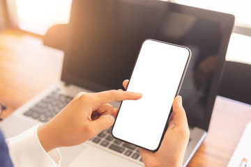 Woman hands using vertical white screen smartphone mockup for graphic display montage.