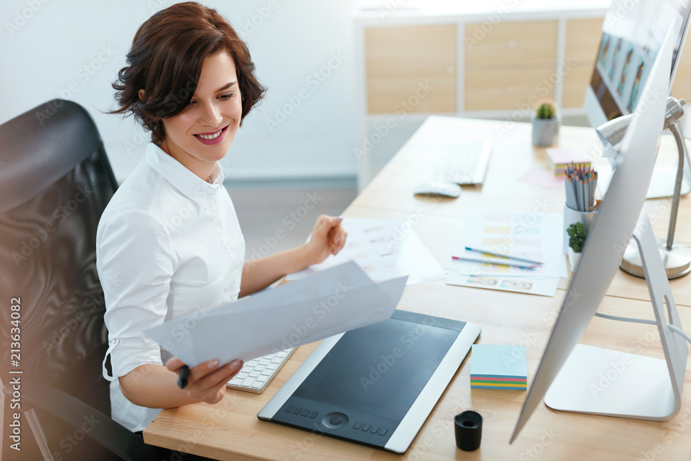 Poster woman working on project on computer in office