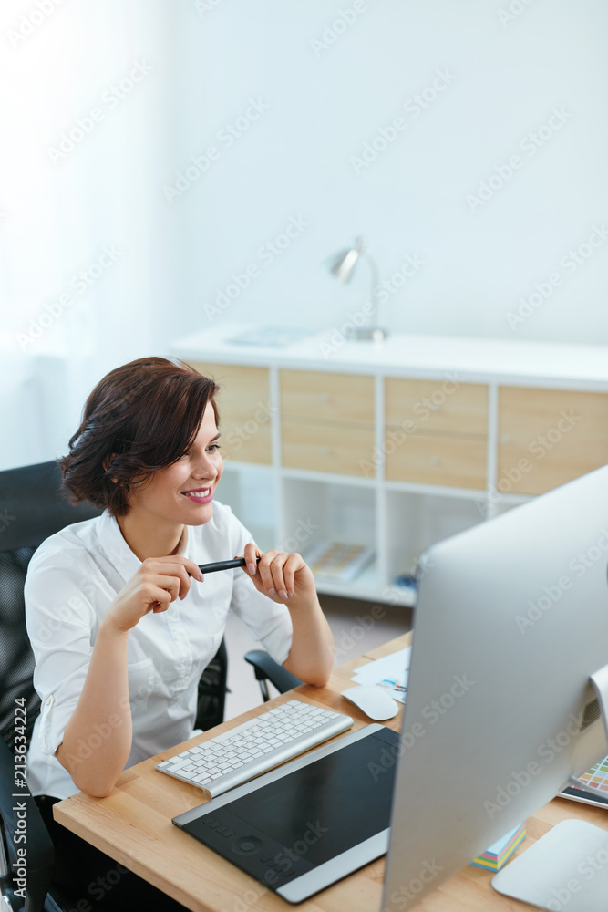 Poster woman working on project on computer in office