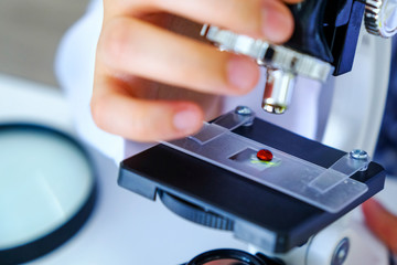 Close up scientist hands woman with microscope, blood test analyzing