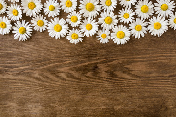 Beautiful, fresh white daisies on vintage rustic table. Wild flowers. Greeting card. Mockup for positive idea. Empty place for inspirational, emotional, sentimental text or quote on brown wooden desk.