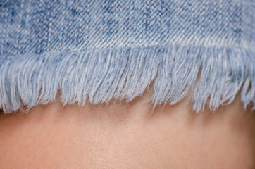Woman in jeans skirt fringe macro fashion denim material