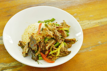 spicy fried duck meat curry with basil leaf and rice on plate