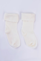 Pair of white wool socks for baby.