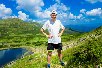 Man traveler on top of mountains near lake. Travel lifestyle concept