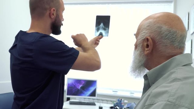 Rheumatologist show radiogram to a mature man