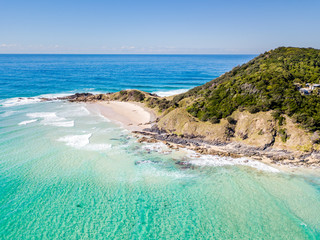 The Pass and Wategoes Beach at Byron Bay from an aerial view with blue water