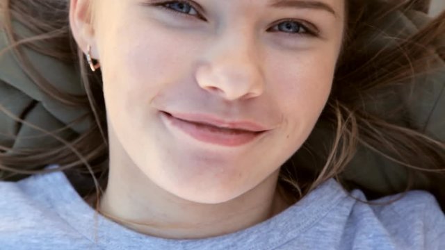 the girl lies on her back and smiles