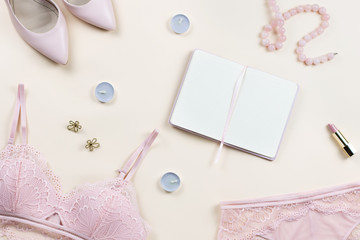 Obraz na płótnie Canvas Fashion blogger workspace with woman elegant pink lace bra and panties, pumps and note book. Stylish lingerie flat lay.