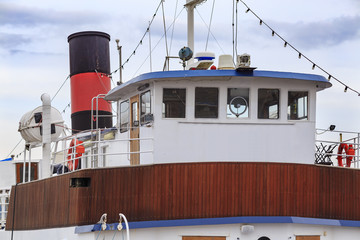 Close up fragment of old retro ship with bridge, deck house and funnel on sky background