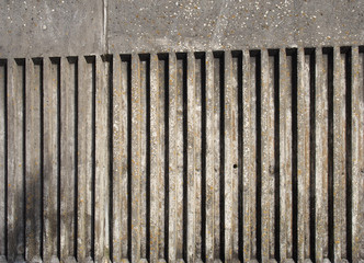 old exterior concrete wall with fluted vertical stripe design with a rough cast texture with shadow