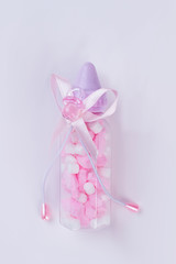 Baby bottle with pills, nipple and bow.