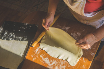 Apple jam next to the baking sheet of rolled dough