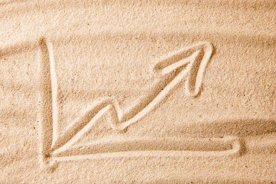 Beach and arrow chart up in the sand. concept of sales growth, growth in prices in the turistic summer season