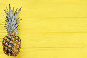 Whole organic pineapple and copy space. Fresh tropical pineapple fruit on wooden surface with text space. Full of vitamins.