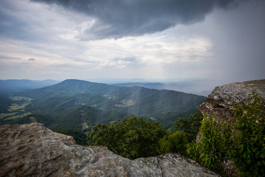 Awesome Scenic view from McAfee Knob of Clouds and Sheets of Rain fall in Valley with mountains in the distance