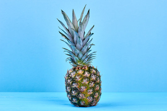 Delicious hawaiian ananas on blue background. Fresh juicy pineapple on blue wooden surface with copy space, horizontal image.
