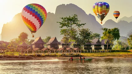 Poster Hot air balloon over Nam Song river at sunset in Vang vieng, Laos. © tawatchai1990