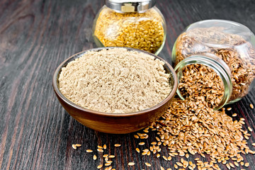 Flour linen in bowl with seeds in glass jars on wooden table