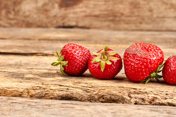 Fresh strawberries on old wood. Organic strawberries on rustic wooden surface. Delicious seasonal...