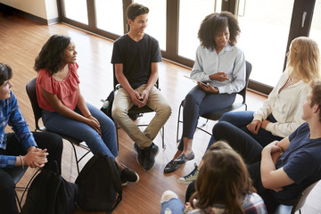 Female Tutor Leading Discussion Group Amongst High School Pupils - obrazy, fototapety, plakaty