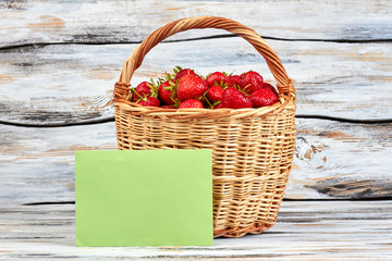 Basket of fresh strawberries on wooden background. Red healthy strawberries in basket and empty...